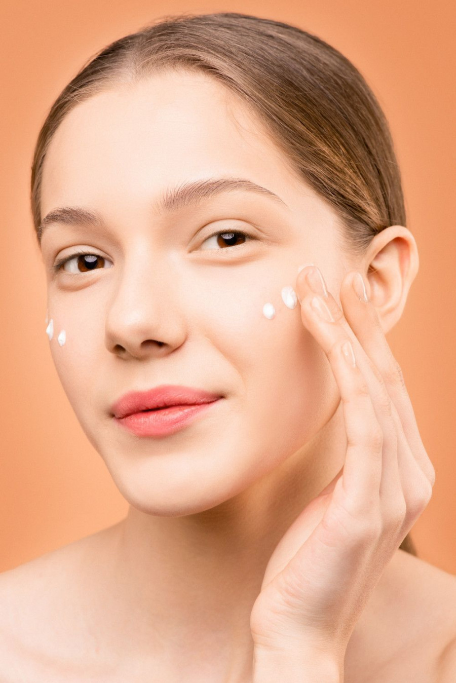 woman with pink lipstick applying facial cream 3762877